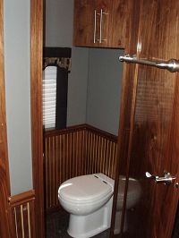 Private porcelain toilet w/beadboard paneling & extra storage